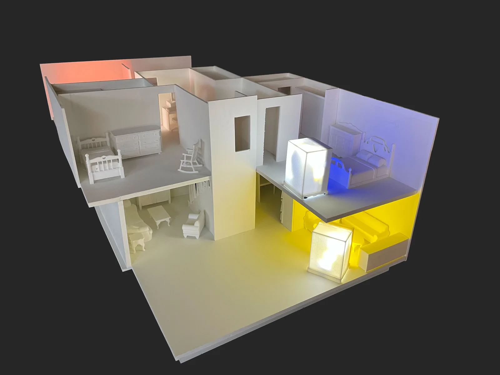 White architectural dollhouse-scale sculpture with colored interior lighting